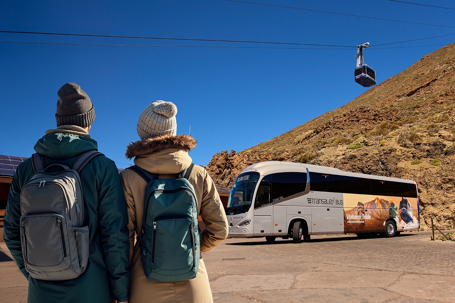 Paar beobachtet das Schauspiel des Teide-Schattens von einem Terrassen-Aussichtspunkt, nach der Bergfahrt mit der Seilbahn