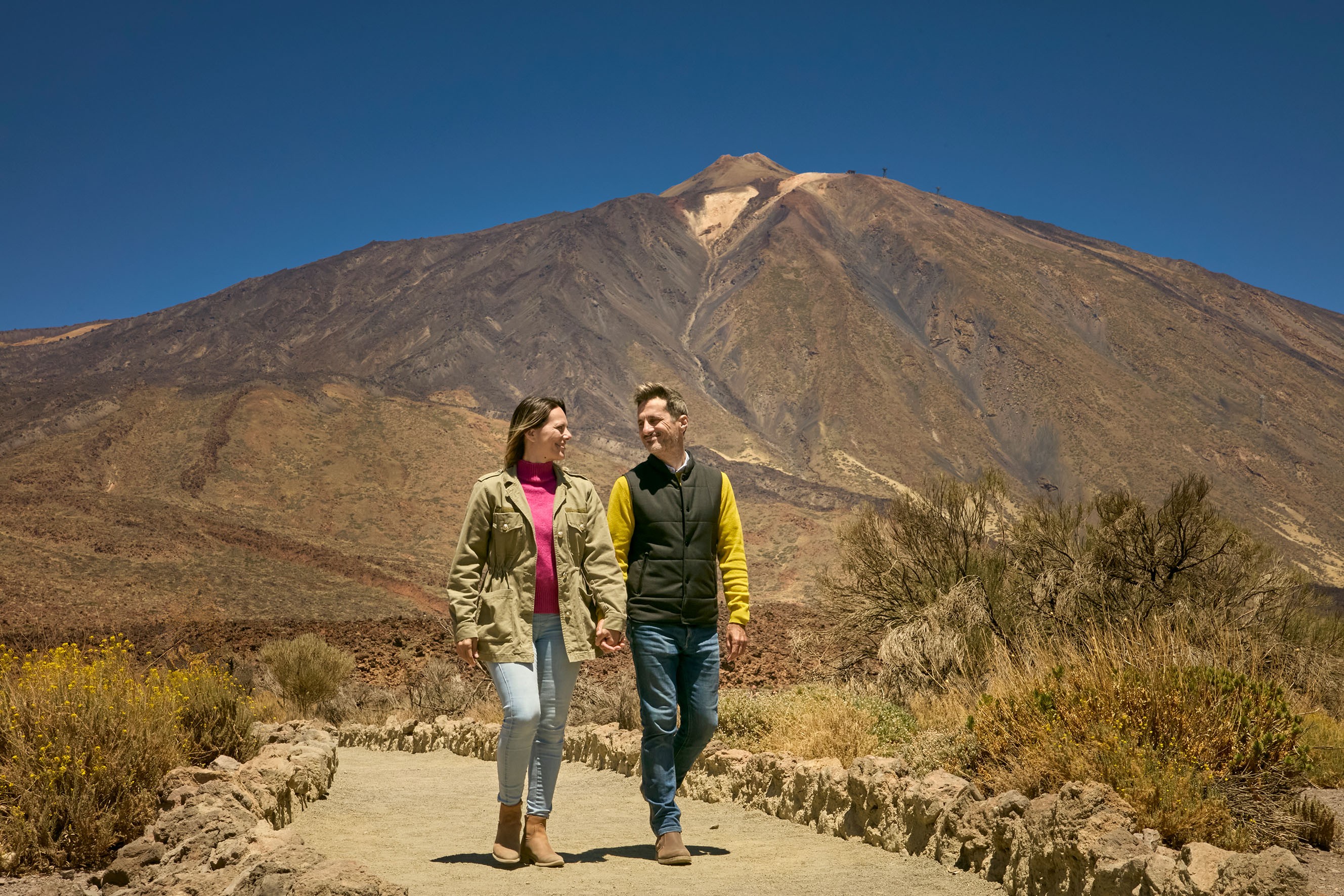 Pareja disfrutando de las vistas con el Teide de fondo durante la excursión exclusiva Teide Tour VIP Pareja disfrutando de las vistas con el Teide de fondo durante la excursión exclusiva Teide Tour VIP