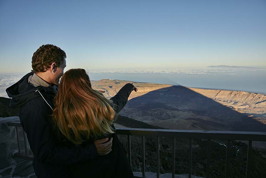 Pareja observando el espectáculo de la sombra del Teide desde las terrazas miradores tras subir en Teleférico